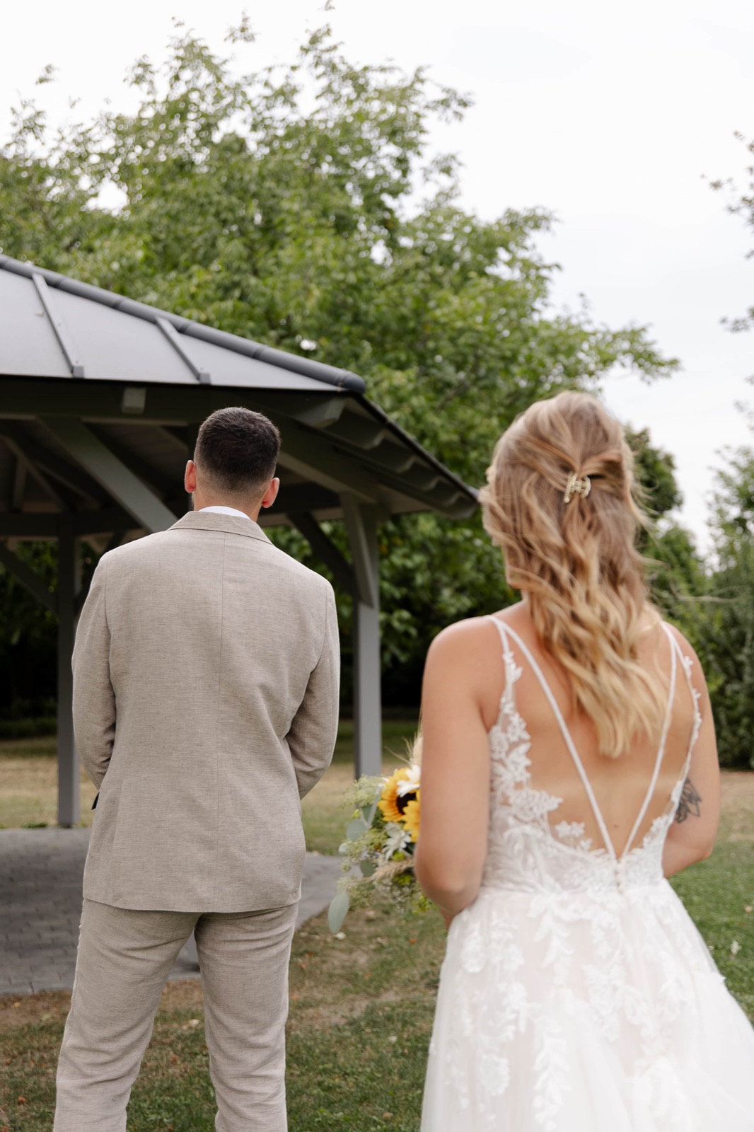 Brautpaar von hinten auf dem Weg zum Pavillon